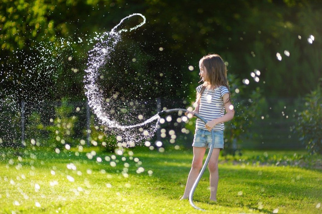 kid playing water hose