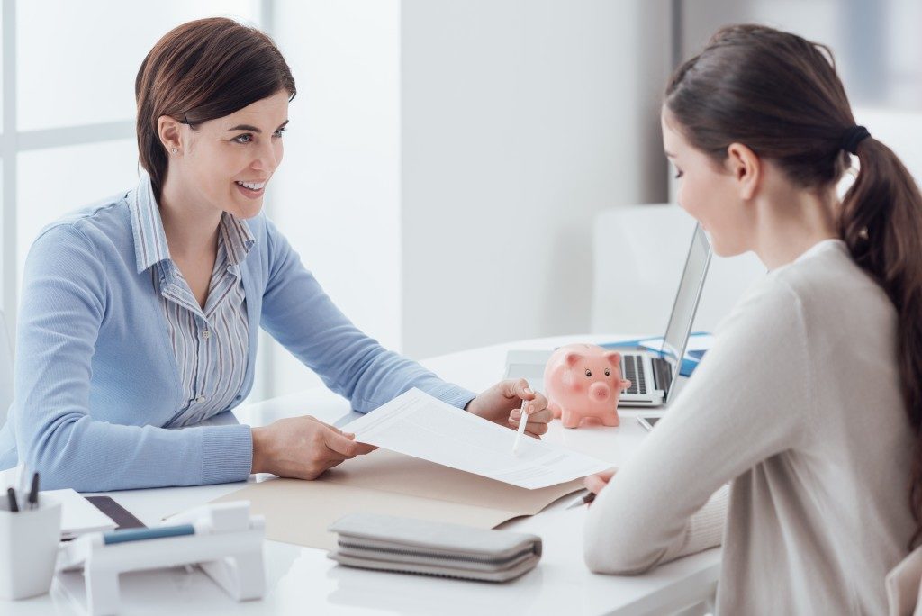 Financial adviser showing insurance policy to client