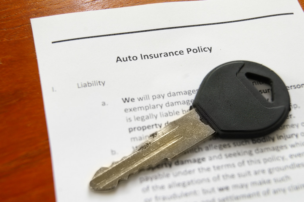 Auto insurance policy papers with a car key on it