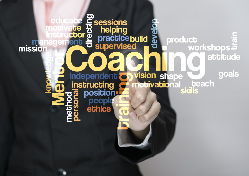 A businessperson pointing as a coaching word cloud