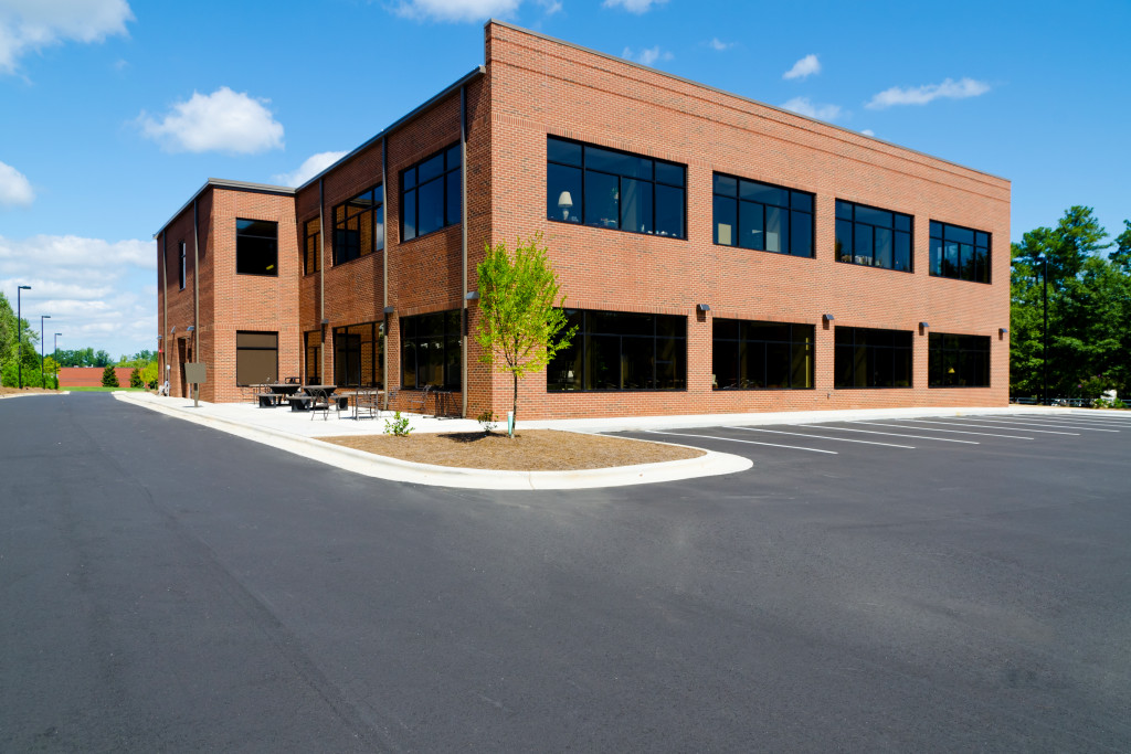 A red-brick commercial building with a spacious parking lot