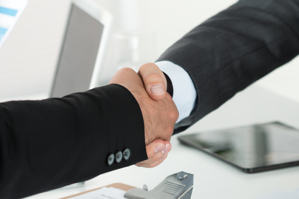 Two businessmen shaking hands in an office setting