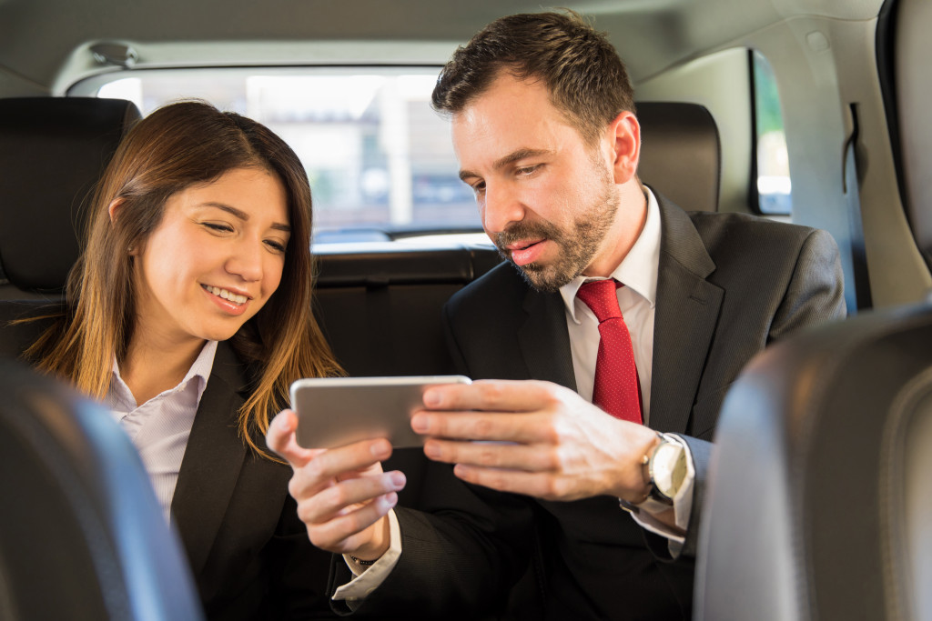 businesspeople riding in the backseat of a car
